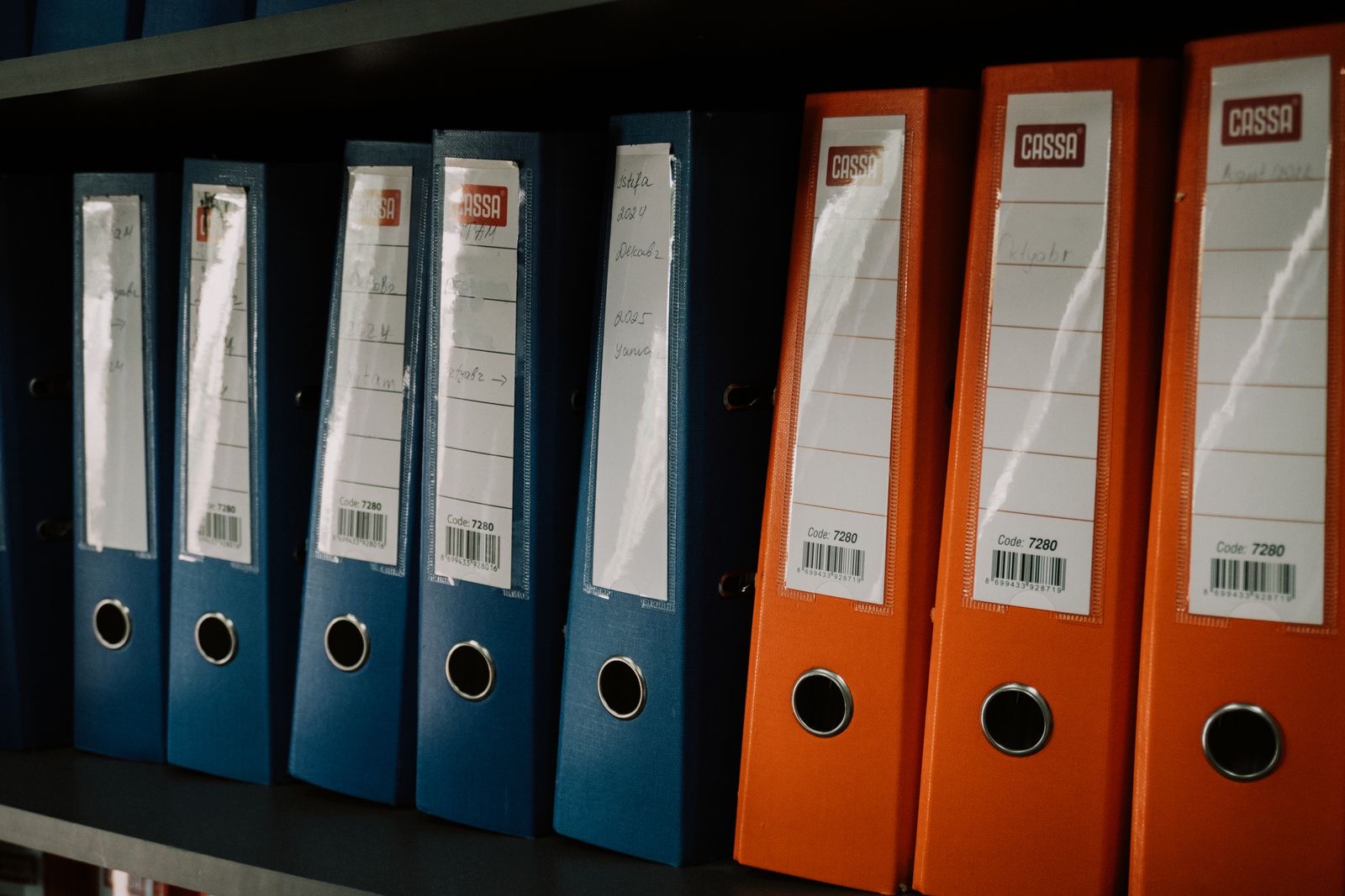 Archive boxes and binders on an office shelf, holding a closed company's books and records.