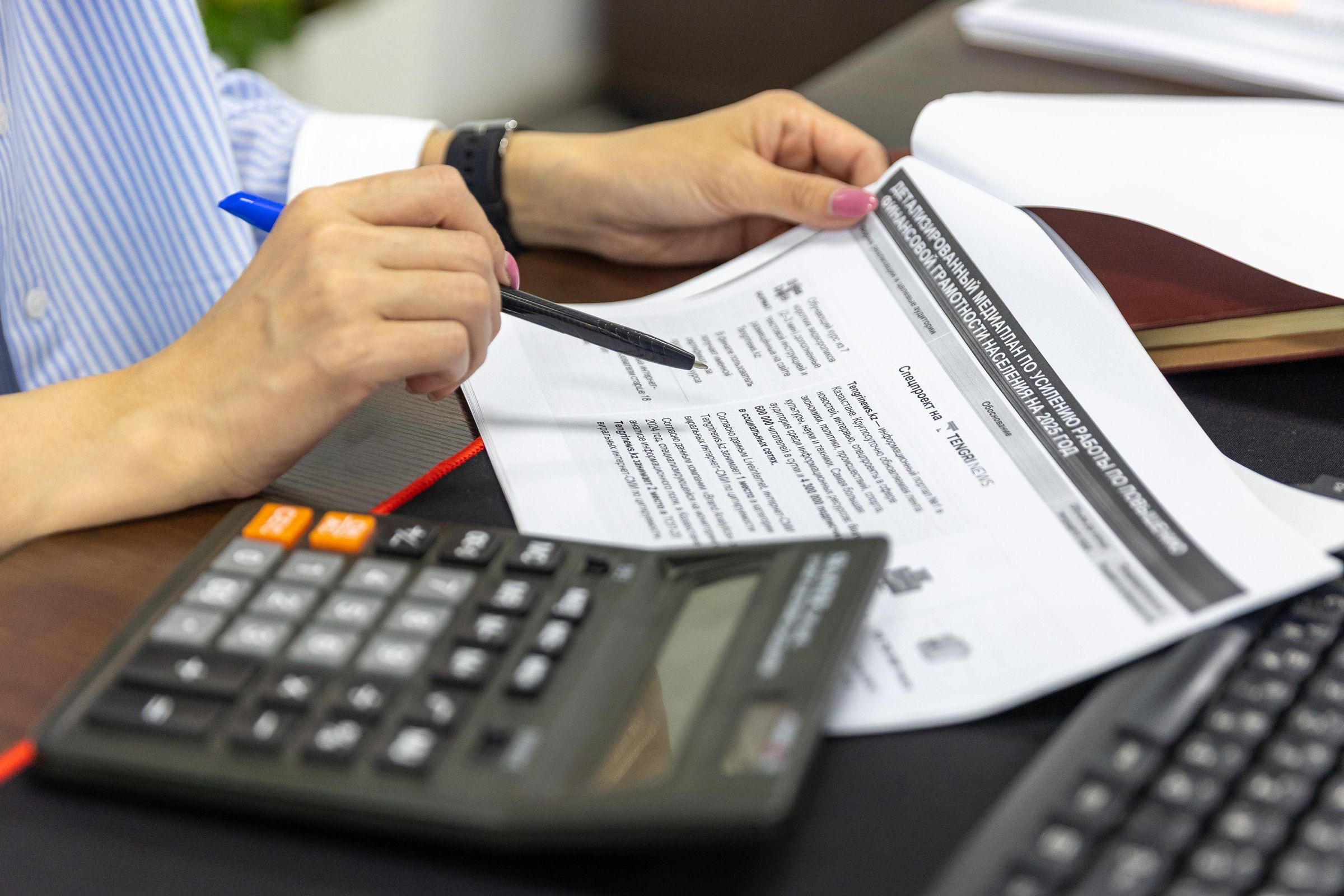 A profit and loss statement and a calculator on a desk by a canal-side window in Amsterdam