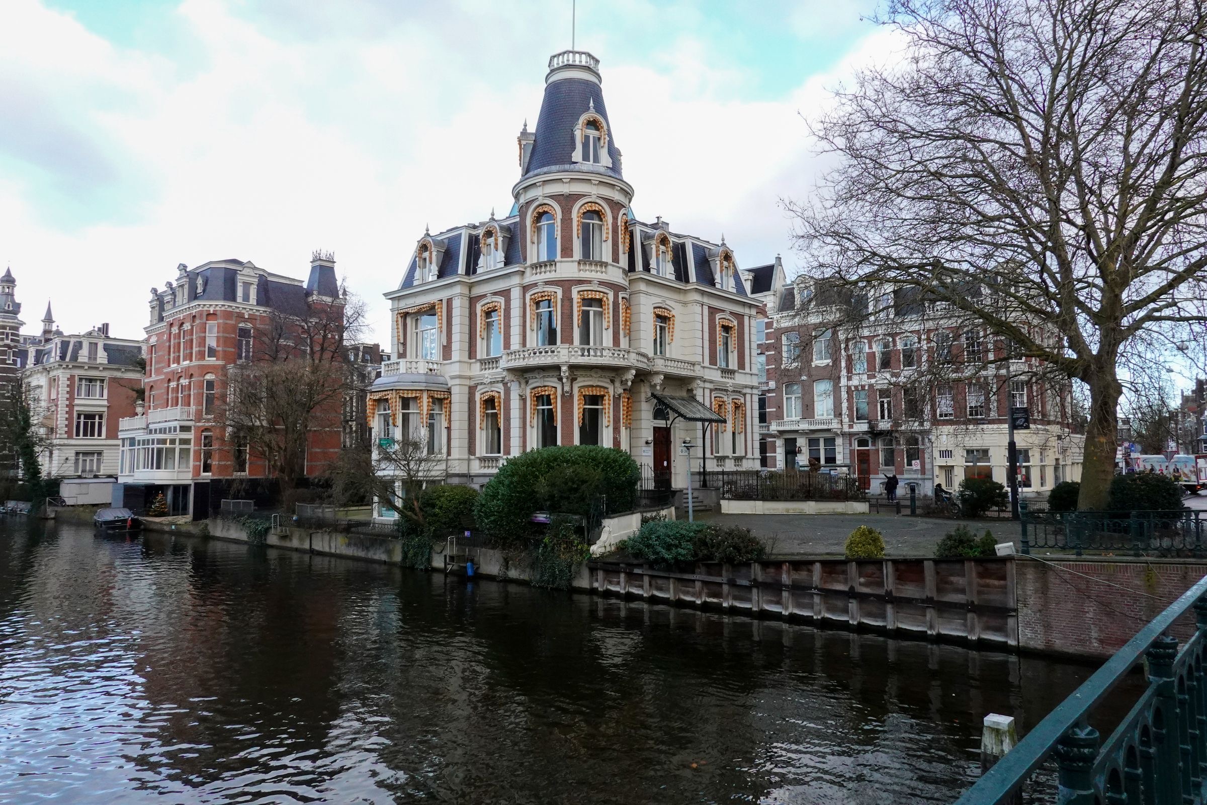 A founder working at a laptop by the window of a canal-side office in Amsterdam.