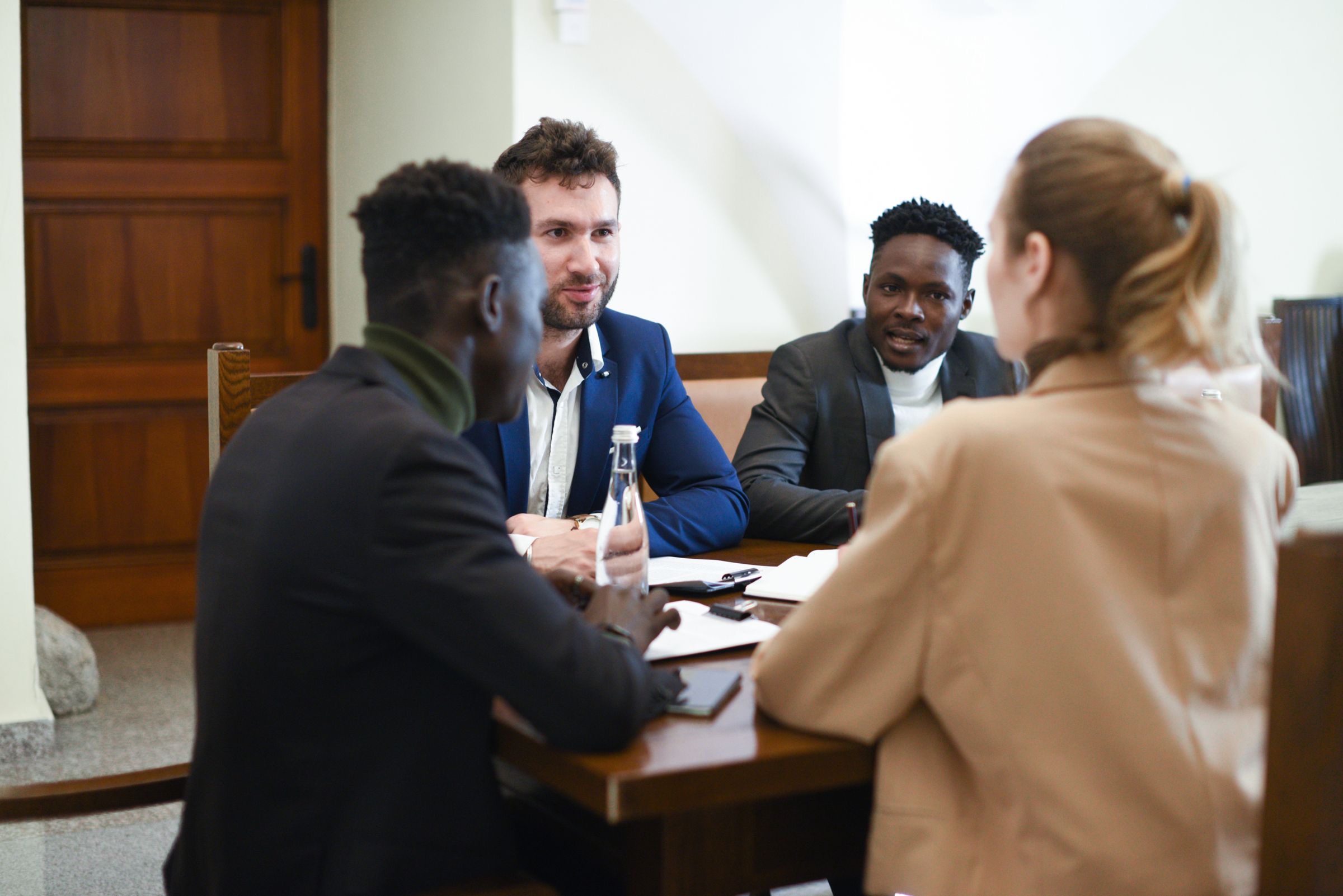Several business partners around one table, discussing printed papers together.