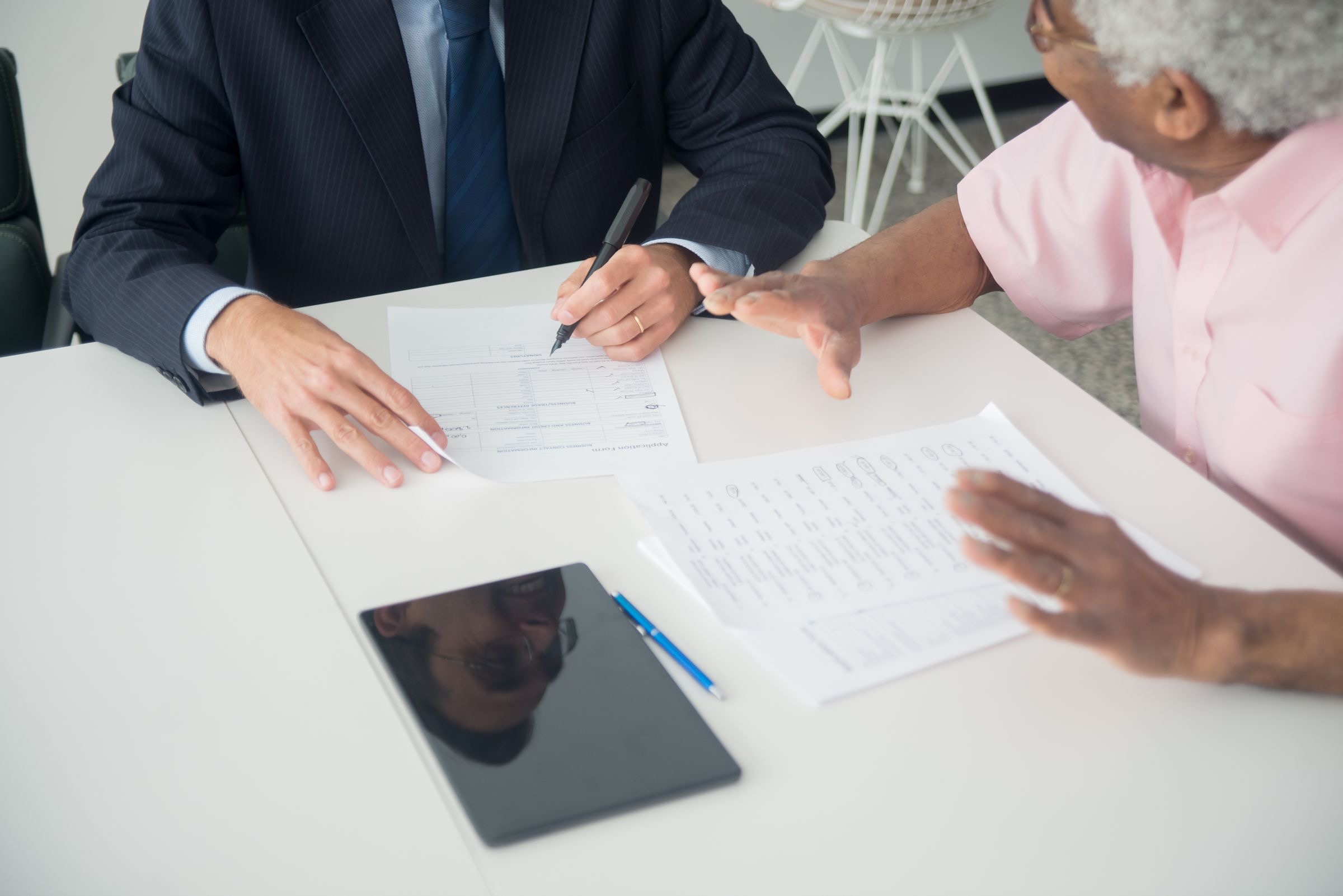 Two business partners reviewing documents together at a shared work table