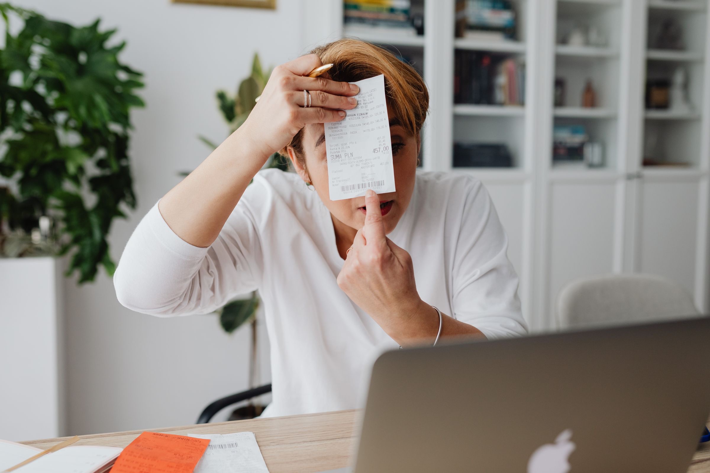 Invoices and a laptop on an office desk