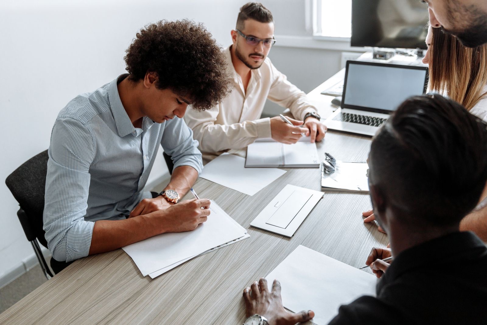 A small start-up team reviewing a business plan and a financial forecast at a meeting table