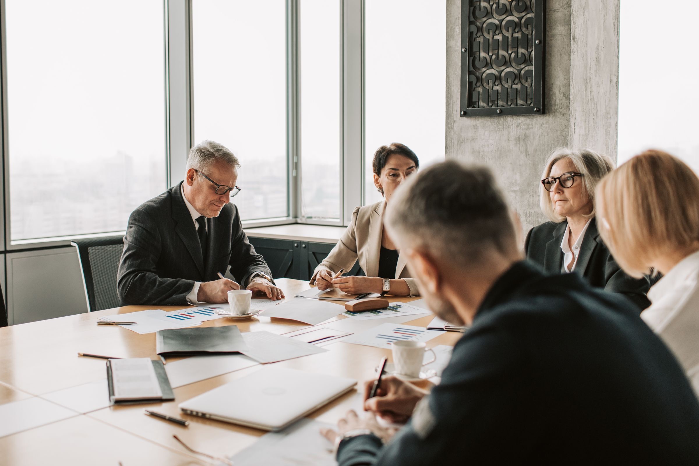 A board reviewing a printed group chart before a Dutch company is added to the structure.