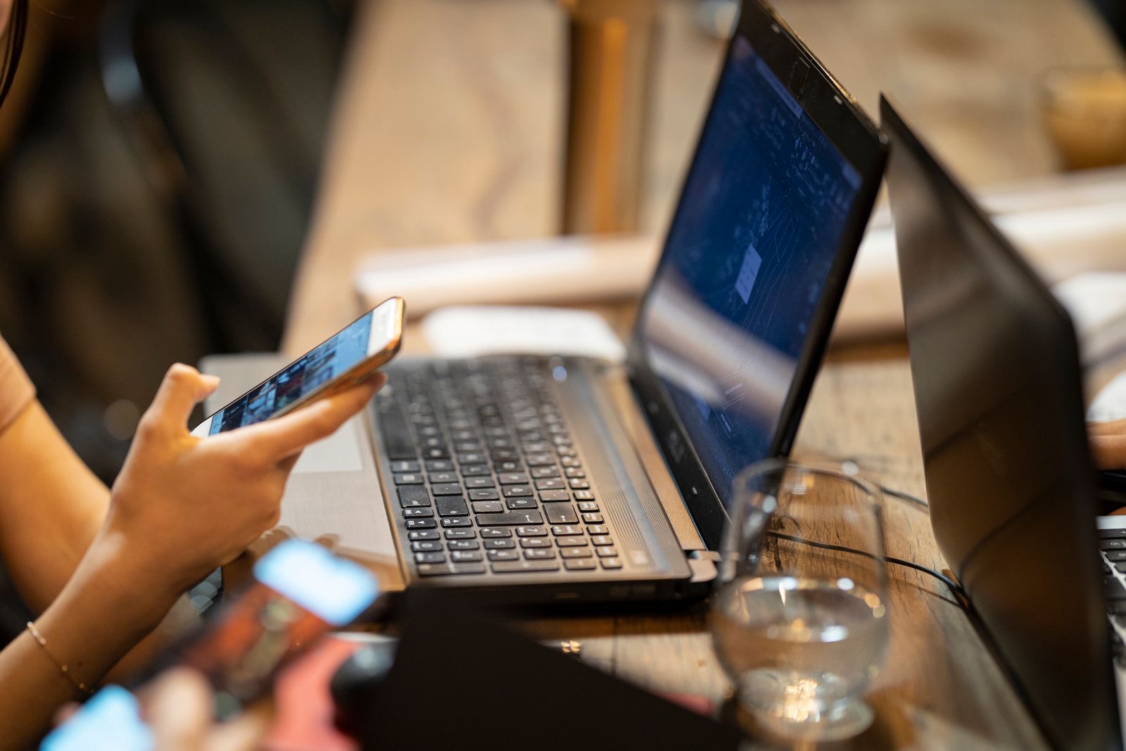 A person logging in to a business portal on a laptop while holding a smartphone