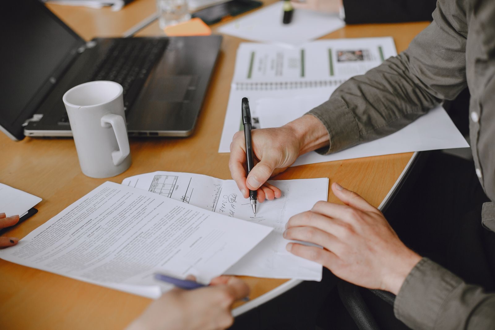 Two people reviewing a contract at a table before signing