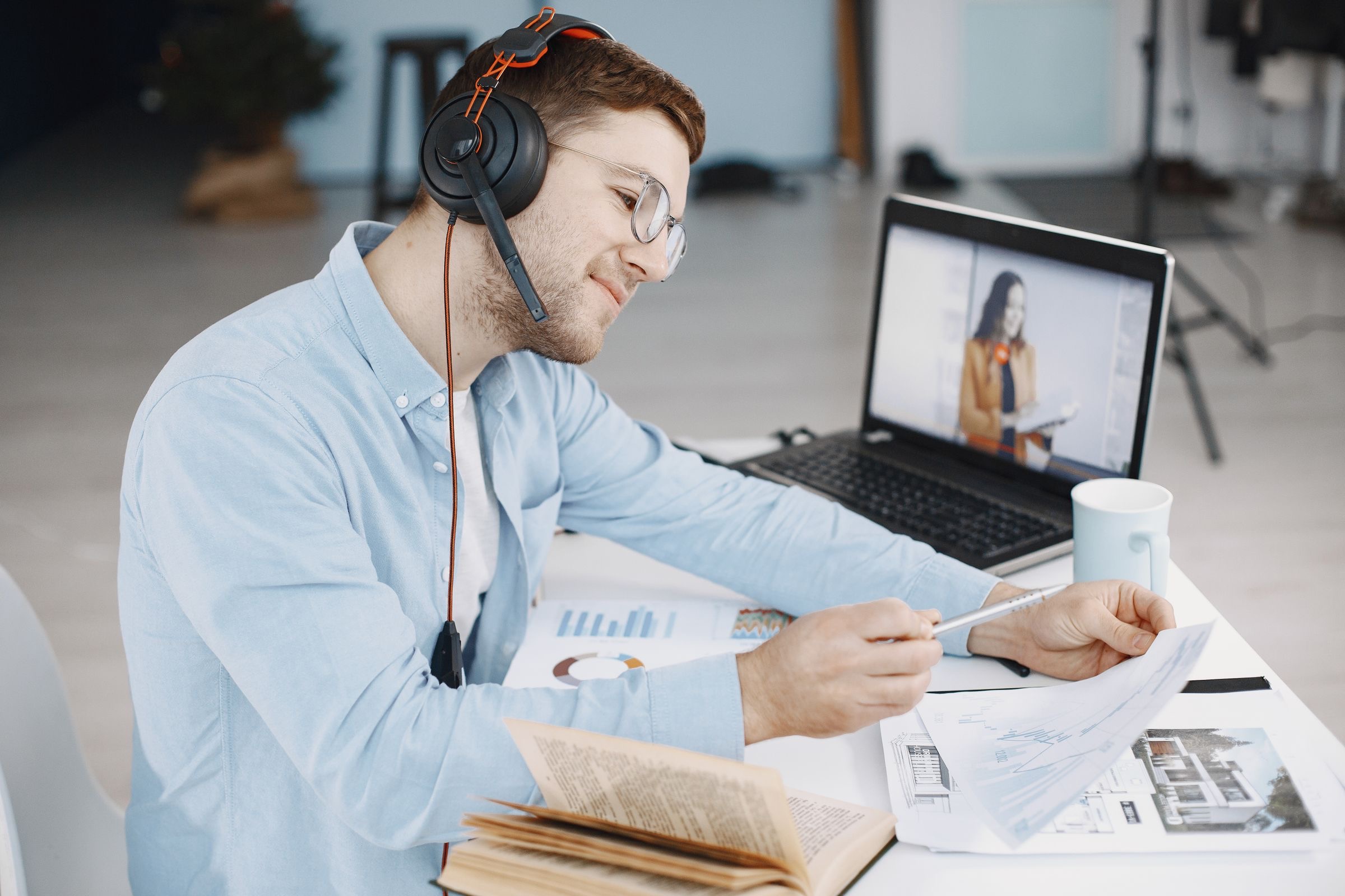 A founder signing a company deed on a laptop during a video call with a notary, a passport and a phone on the desk.