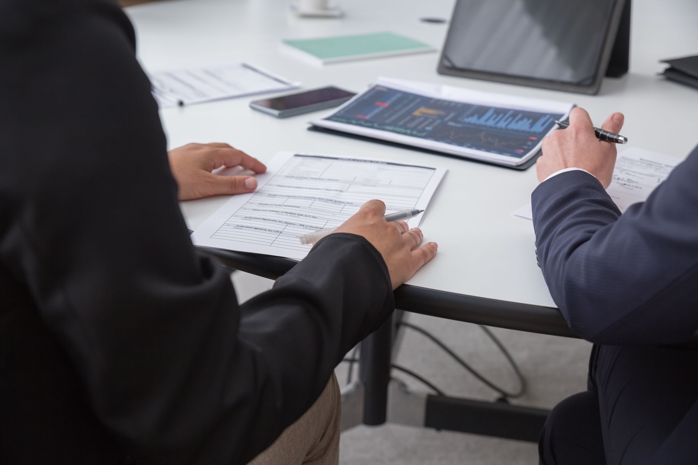 A small payments team reviewing compliance documents at a laptop while preparing a payment institution licence application.