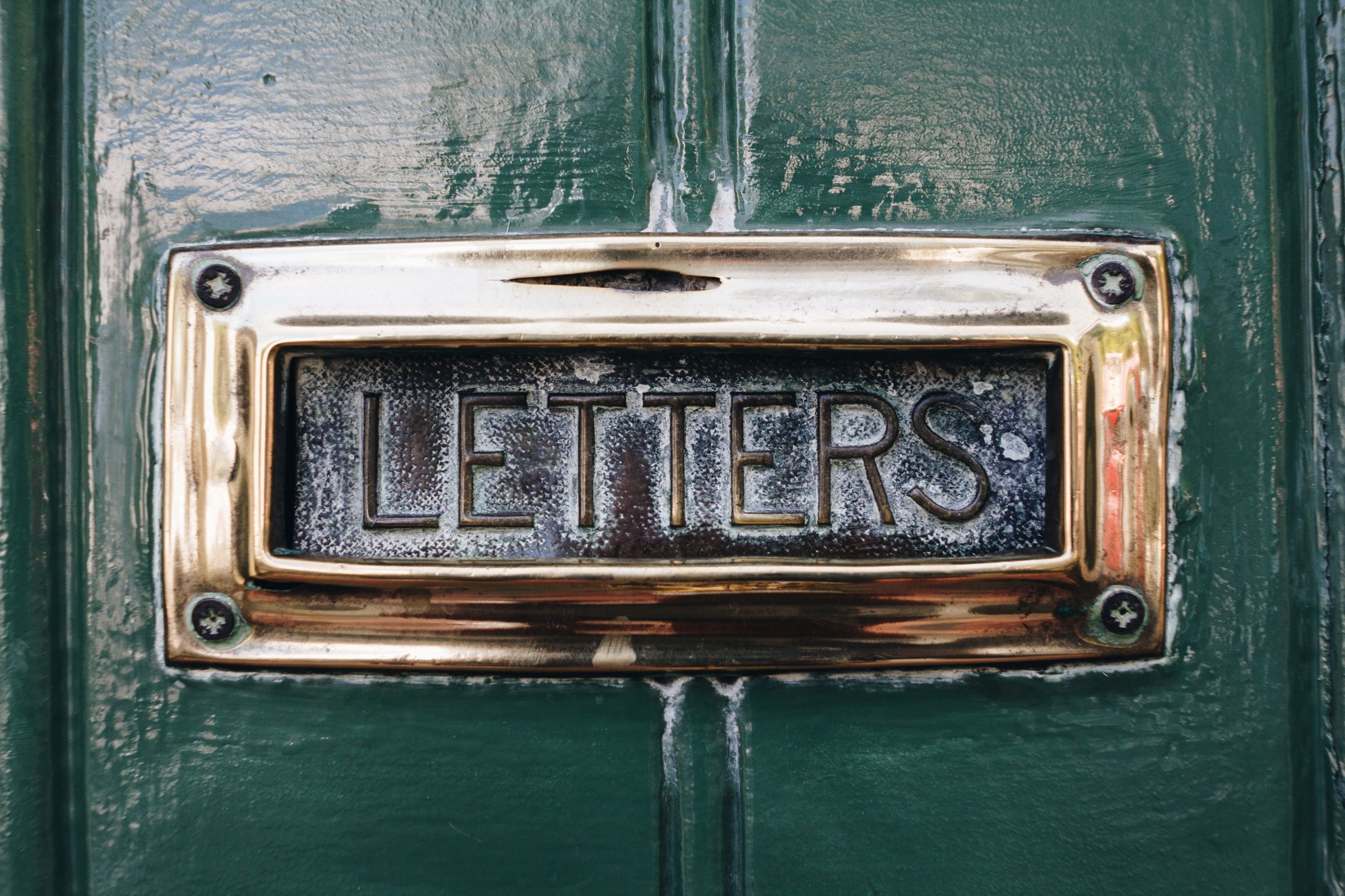 The entrance of an Amsterdam canal house with a brass letterbox, the kind of building that hosts business addresses.