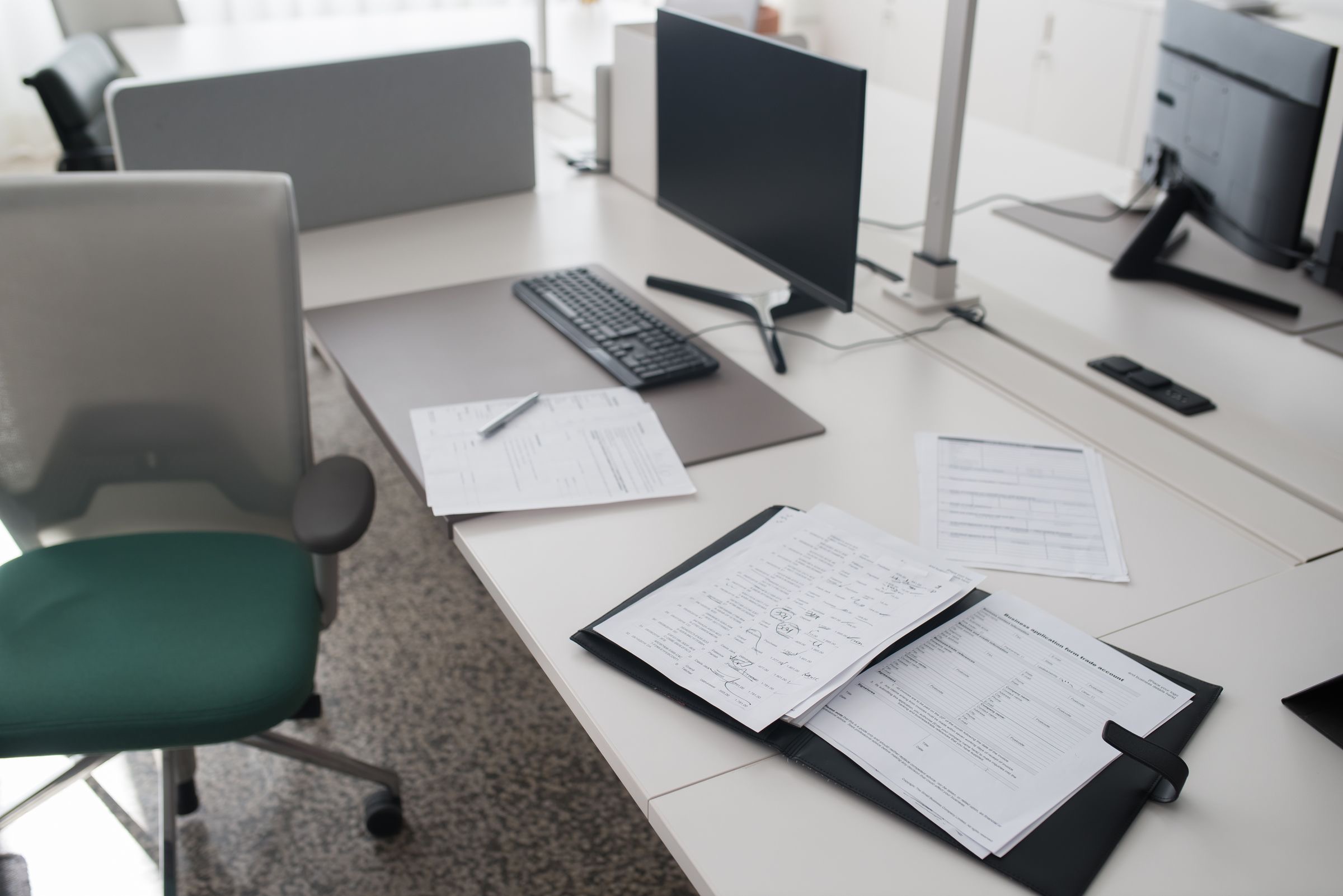 Company ownership papers and a closed passport on a desk beside a pen